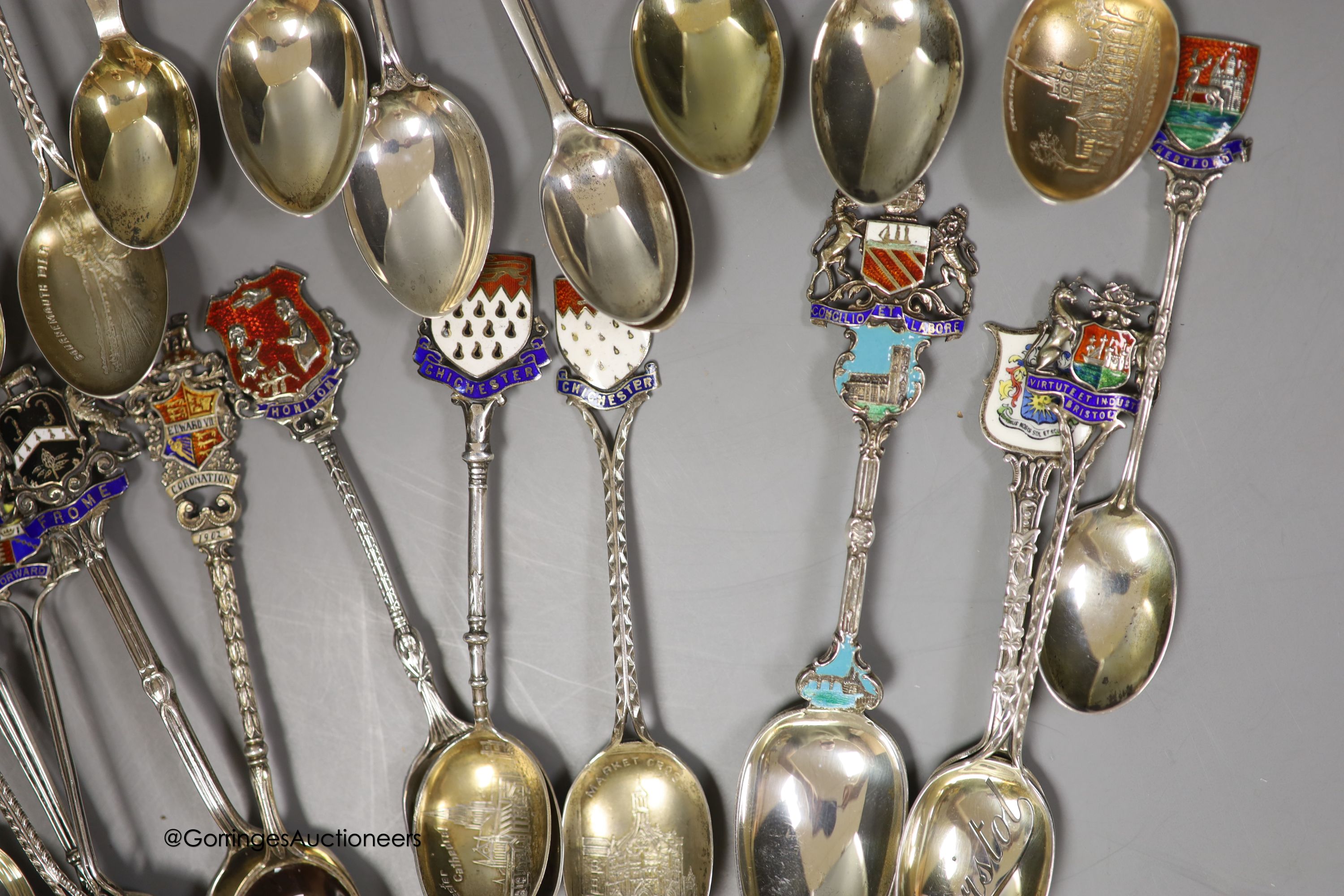 Twenty five assorted 20th century silver and enamel souvenir spoons, including Brighton, Bournemouth, Eastbourne, Chichester etc. and and Edward VII Coronation spoon, together with a similar white metal spoon, gross weig